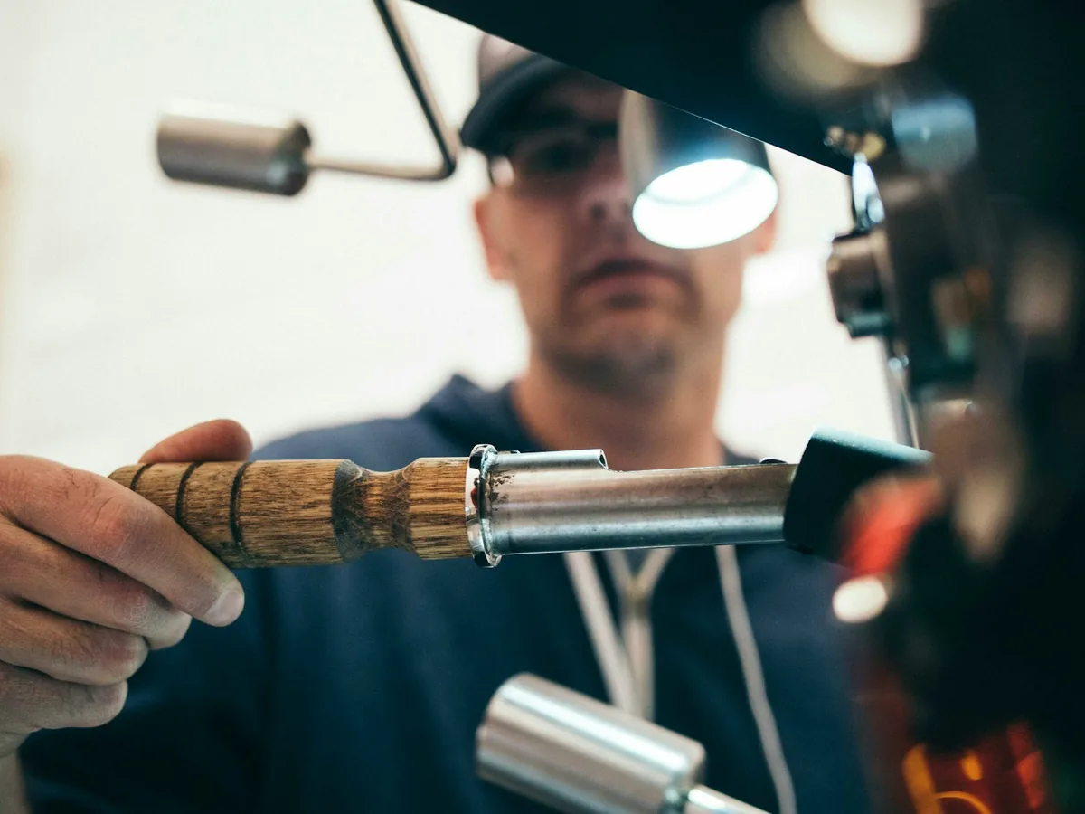 A heating engineer soldering copper pipework by the light of a head torch.
