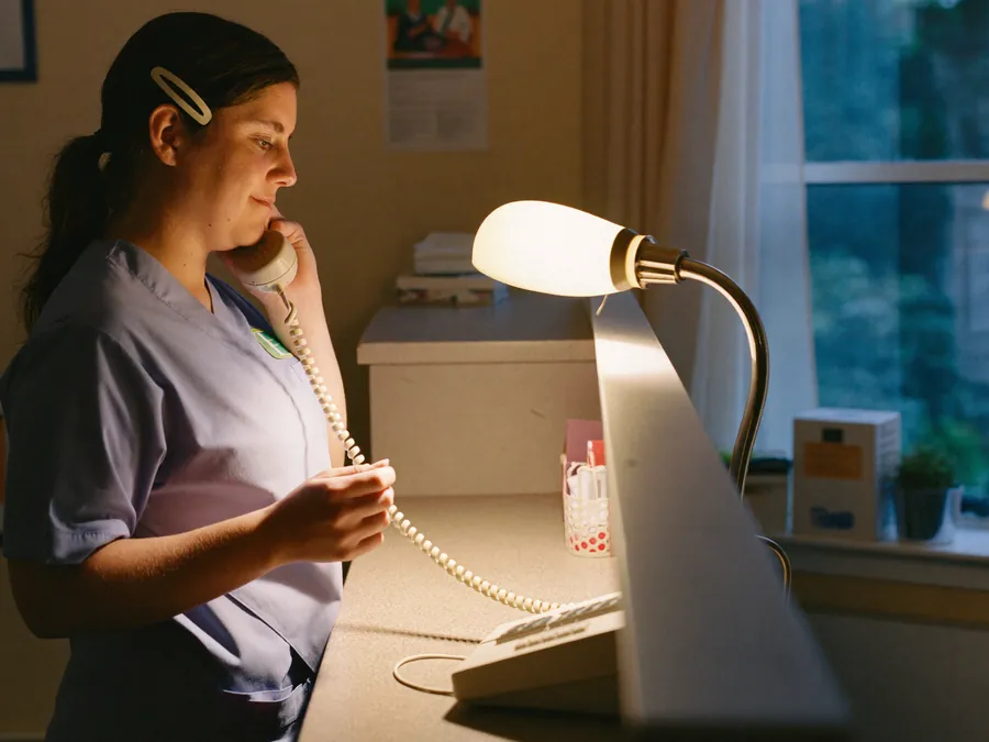 A veterinary nurse on the telephone at reception in the evening