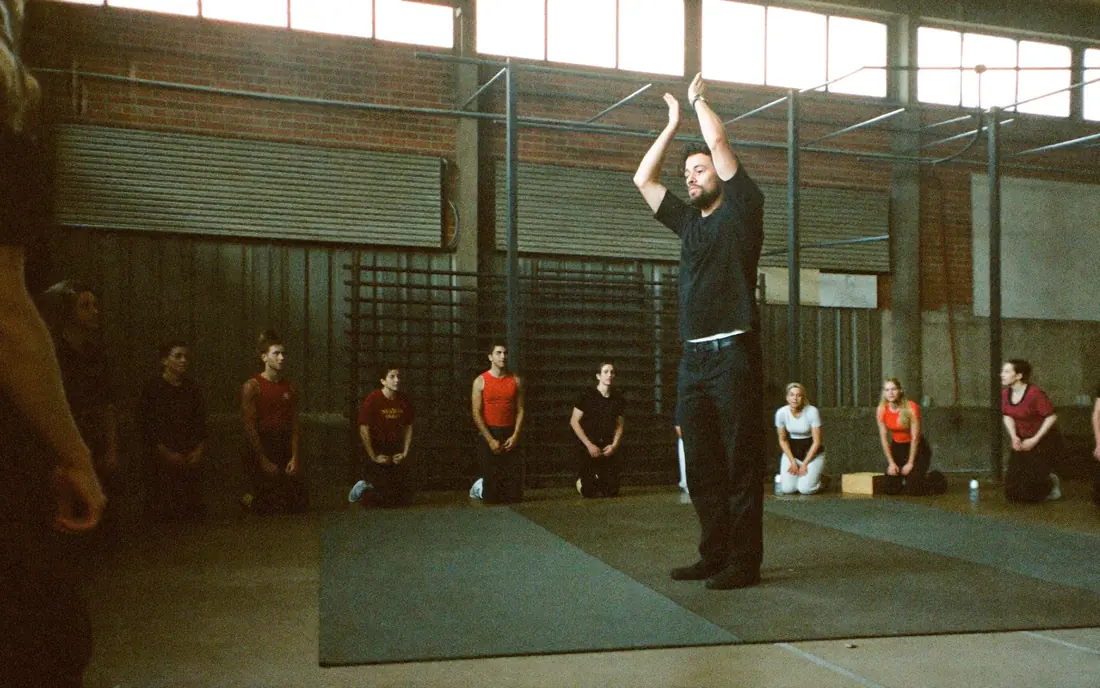 A coach demonstrating a technique to a semicircle of adults