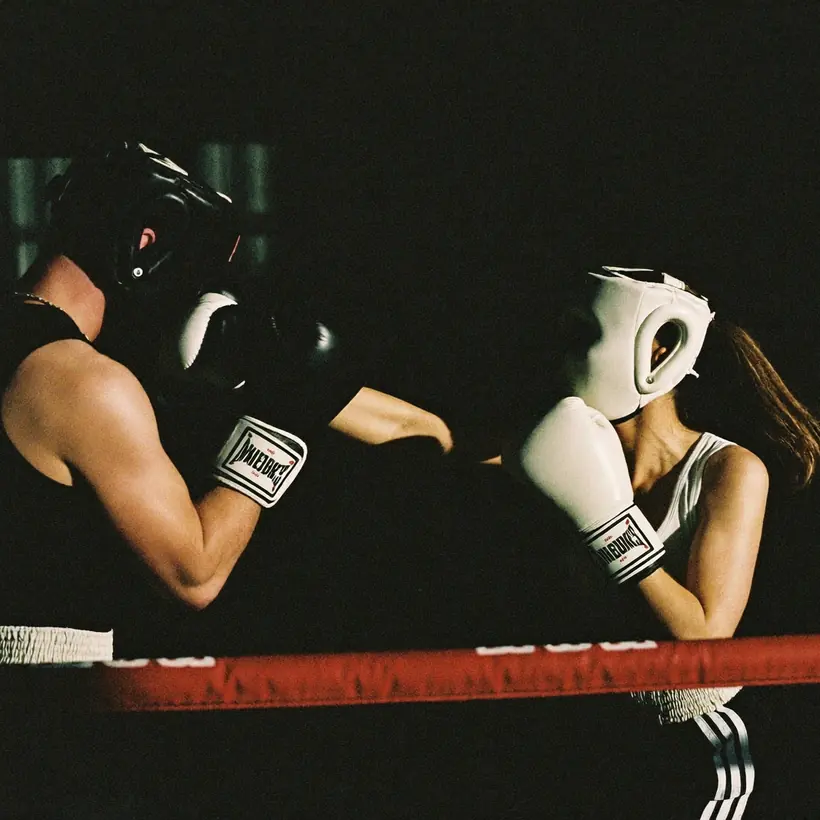 Two boxers sparring in headguards in a ring