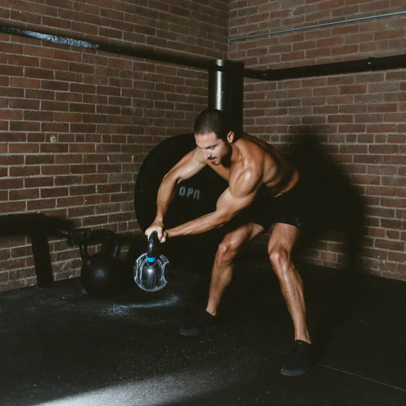 A man doing a heavy kettlebell swing on the strength floor