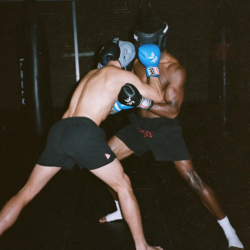 Two men sparring Muay Thai in the clinch