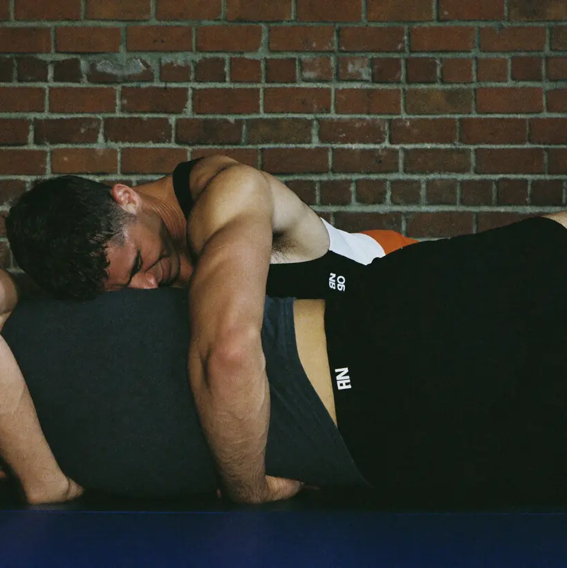 Two wrestlers mid-takedown on the mat