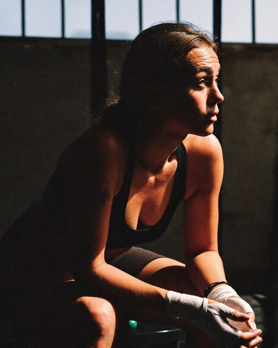 A fighter resting between rounds, hands on knees