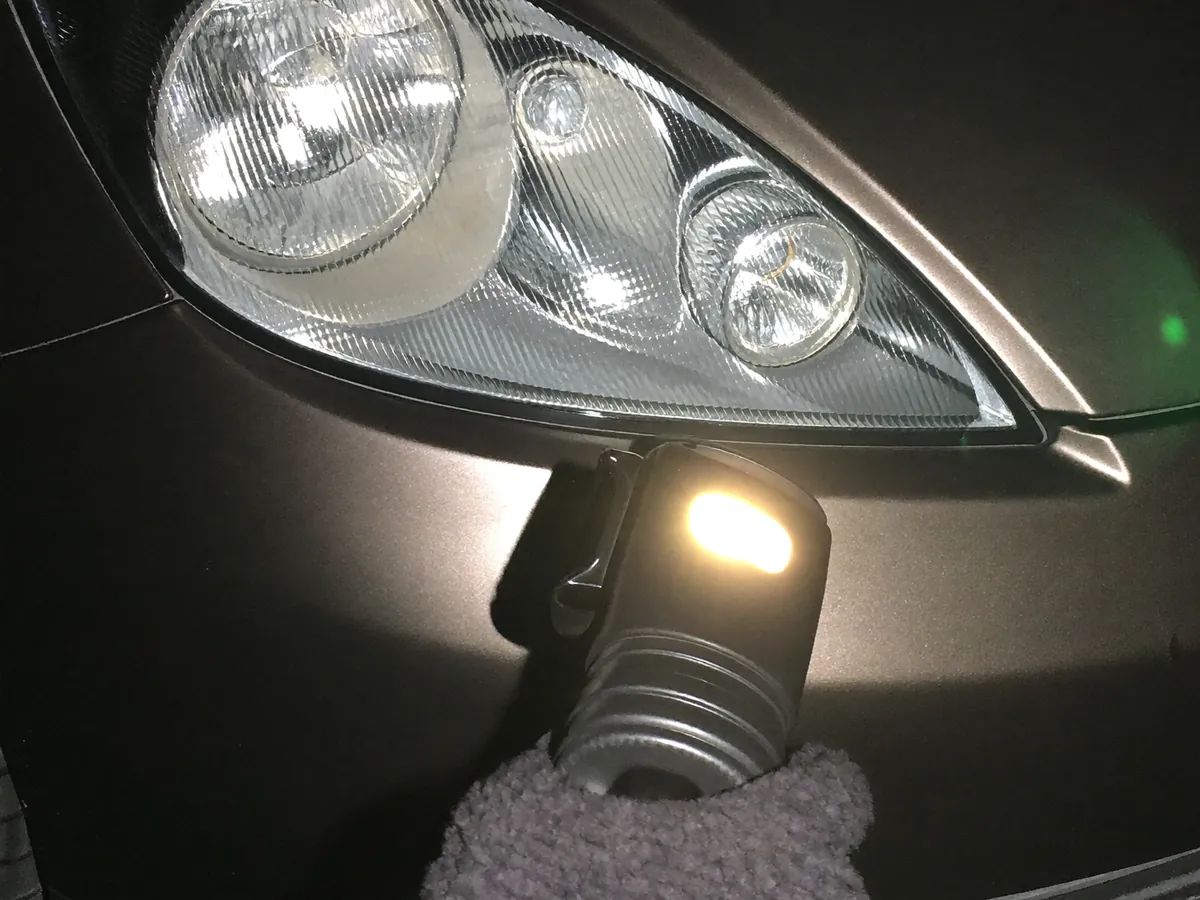 A car headlight being checked with an inspection lamp