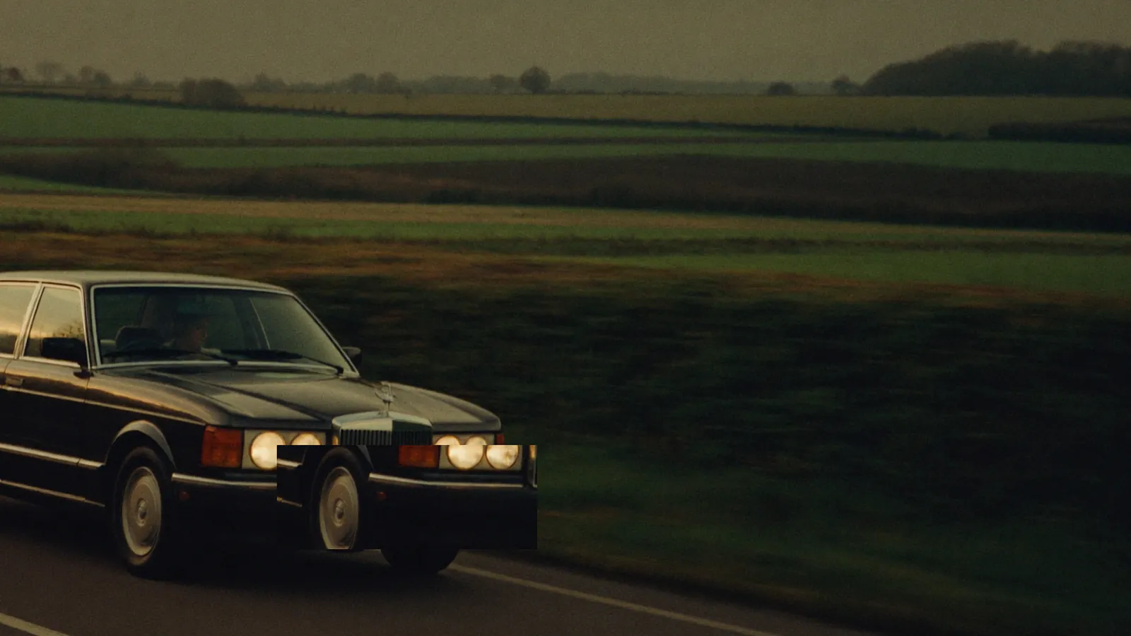 A car on an empty country road at dusk