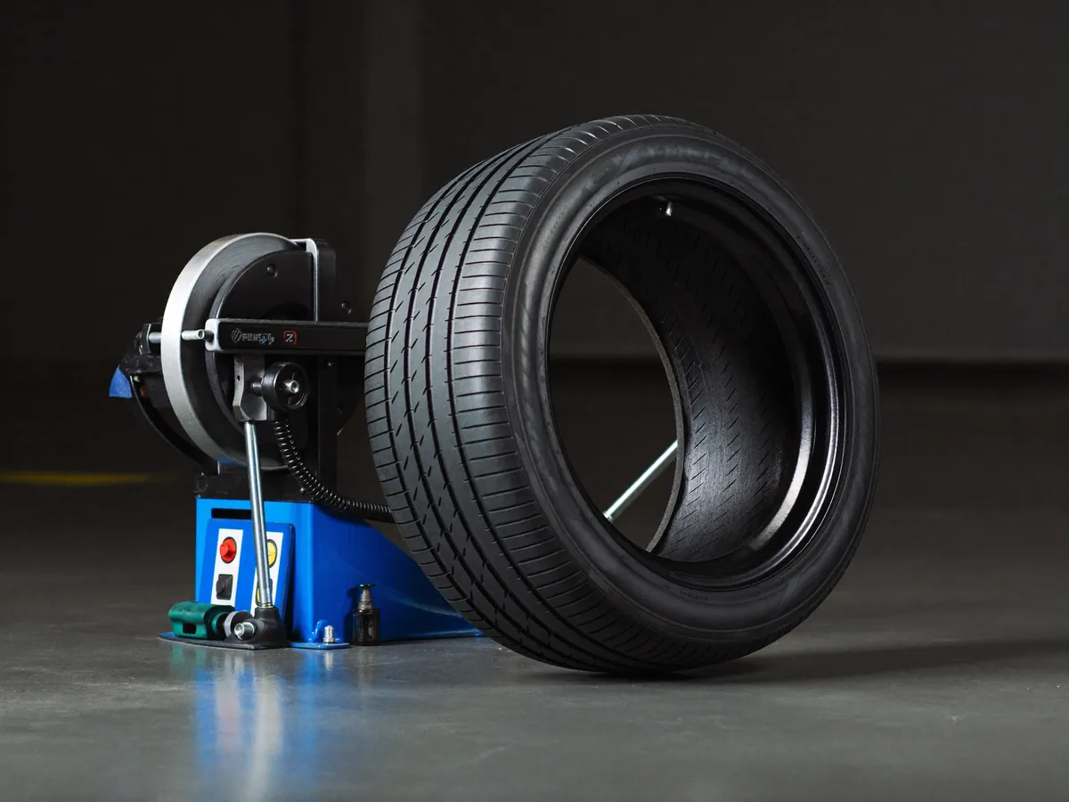New tyres stacked beside a wheel balancing machine