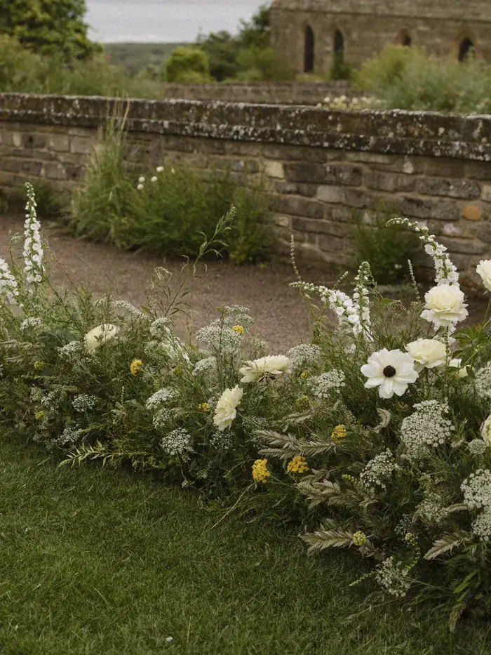 A loose meadow of cream flowers along a stone church aisle