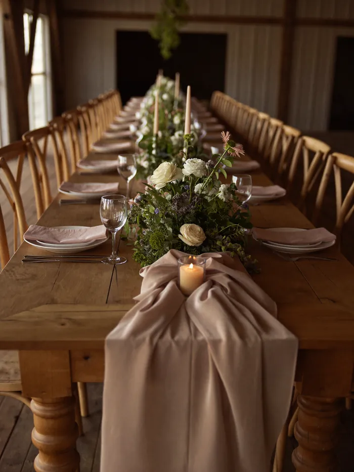 A low flower runner down a long wooden banquet table