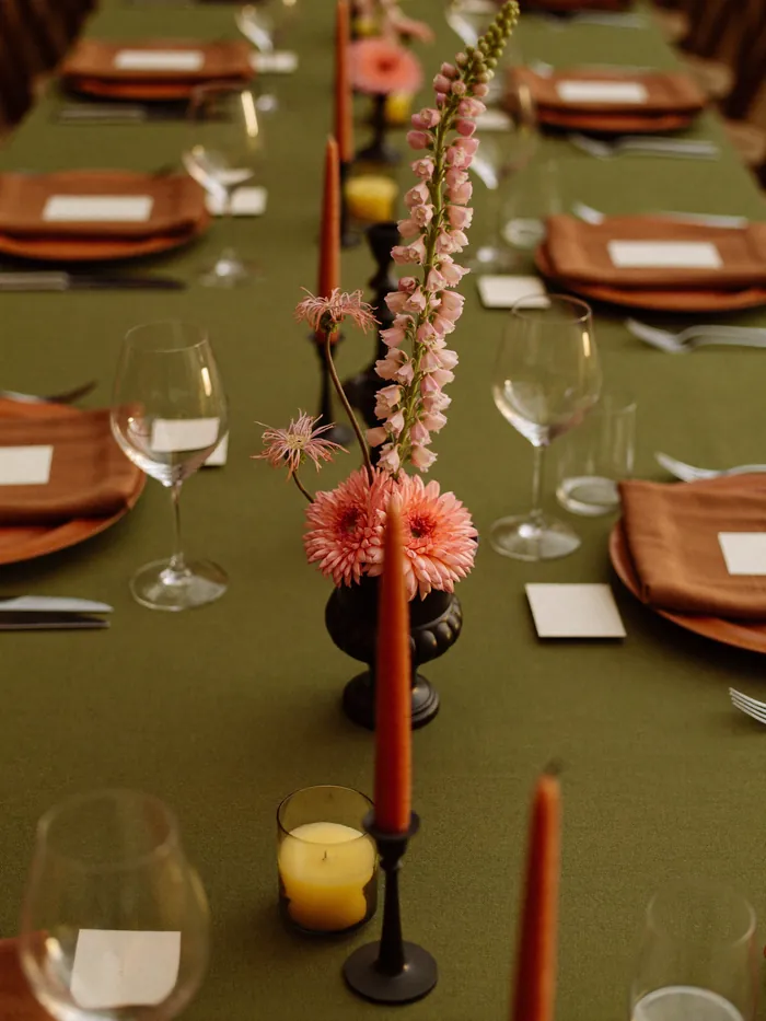 A reception table with an olive cloth and a coral centrepiece